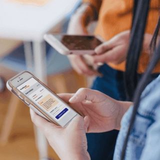 Persoon met lang zwart haar bekijkt via smartphone website van Noodfonds