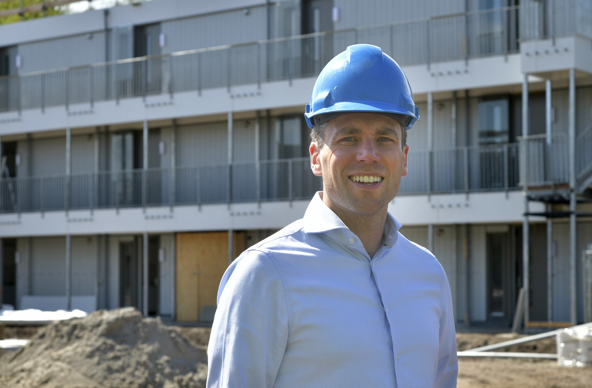 Rens in lichtblauwe blouse met bouwhelm op de bouwplaats